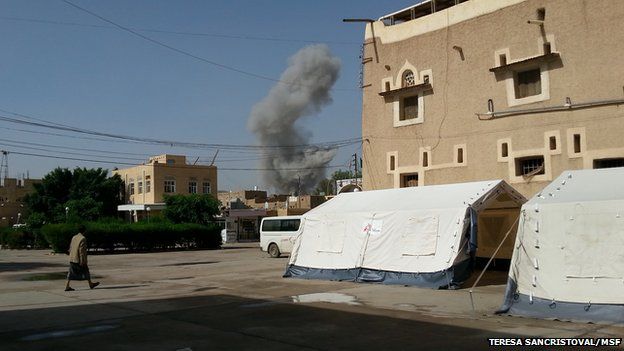 Smoke rises in distance behind buildings in Saada on 9 May 2015