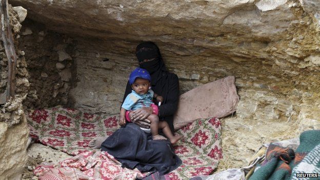 An internally displaced woman sits with a child in a cave in the district of Khamir of Yemen"s northwestern province of Amran 9 May 2015
