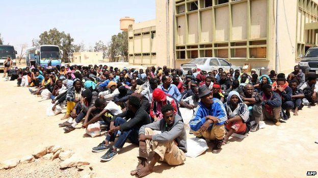 Migrants from sub-Saharan Africa sit at a centre for illegal migrants in the al-Karem district of the Libyan eastern port city of Misrata, 9 May 2015