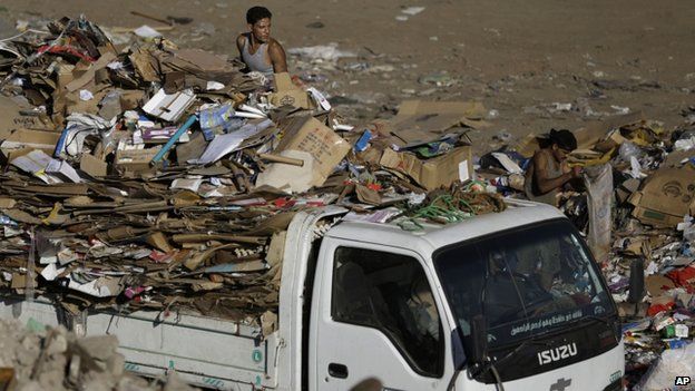 Egyptian rubbish truck collectors on a truck sifting through rubbish in Cairo, Egypt, on 23 October 2014