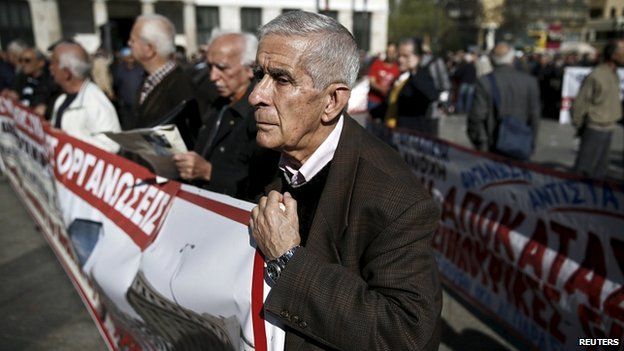 Pensioner holds banner during anti-austerity demonstration in Athens. 1 April 2015