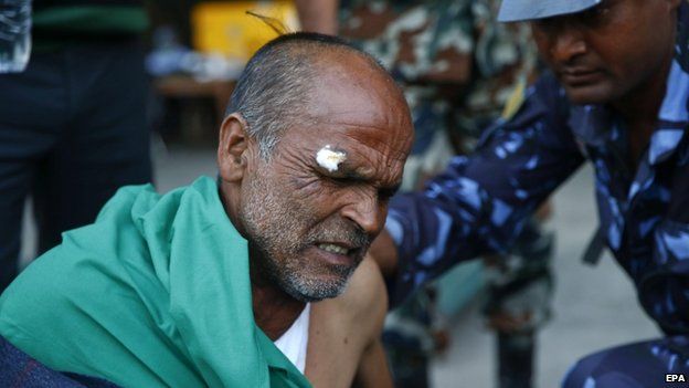 An injured man is treated at Kathmandu airport, 12 May