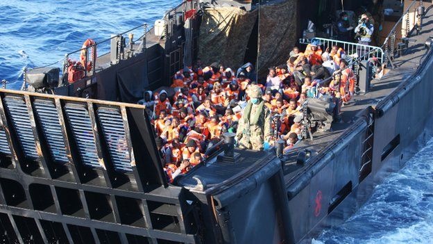 A landing craft full of rescued migrants about to embark HMS Bulwark.
