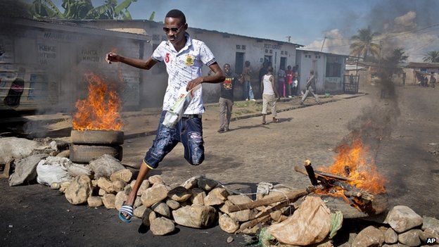 A civilian jumps over a burning barricade of rocks erected by residents to protect themselves from police, in a northern district of the capital Bujumbura, in Burundi 14 May 2015