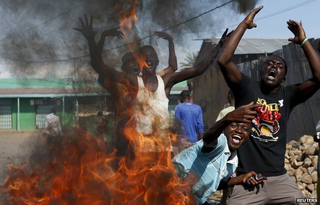 Protesters, who are against President Pierre Nkurunziza"s decision to run for a third term, gesture in front of a burning barricade in Bujumbura, Burundi 14 May 2015.