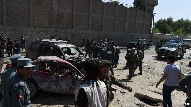 Afghan and foreign security forces inspect the site of a suicide attack in Kabul, 17 May 2015