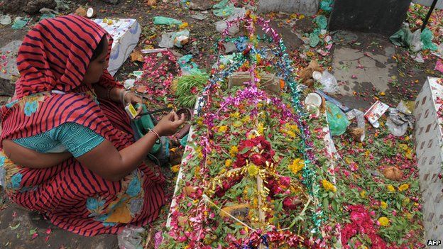An Indian woman from the Hindu Devipujak community burns incense on the grave of her dear departed as she observes 'Divaso', an annual memorial day for the departed souls, at a graveyard in Ahmedabad on July 26, 2014.