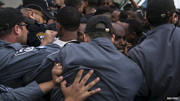 An Israeli of Ethiopian descent reacts as he is pushed by police officers during a protest in Tel Aviv, Israel, on 3 May