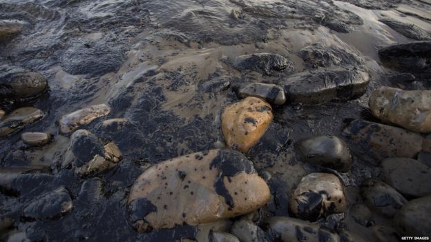 Rocks and sand covered in oil