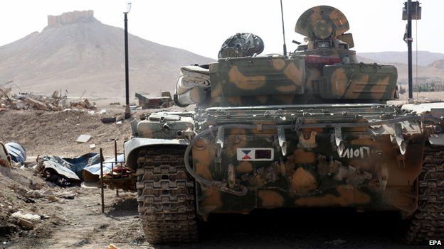 A Syrian armoured tank takes up position during fighting against IS militants in the ancient oasis city of Palmyra