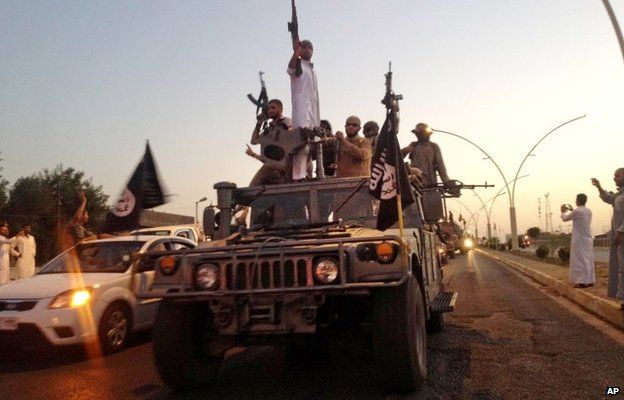 Islamic State militants drive through the Iraqi city of Mosul after its capture on 23 June 2014