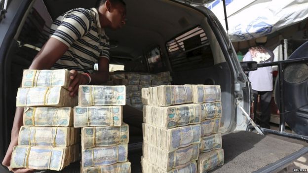 A man prepares to remove bundles of local currency from the trunk of a truck in Hargeisa, Somaliland - 19 May 2015