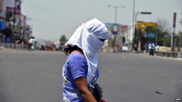 An Indian woman with her face covered crosses the road on the outskirts of Hyderabad on May 25, 2015