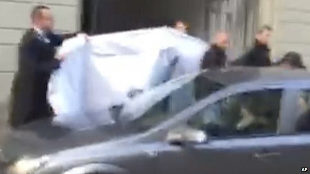 Image taken from a mobile phone shows hotel employees hiding the identity of a person led out of the hotel in Zurich on 27 May 2015