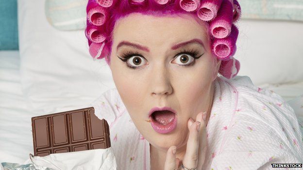 Surprised woman munching chocolate