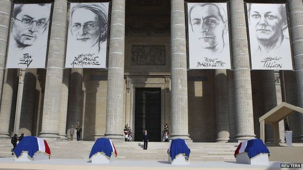 French President Francois Hollande (C) stands on the steps in front of the flag-draped coffins of French Resistance figures