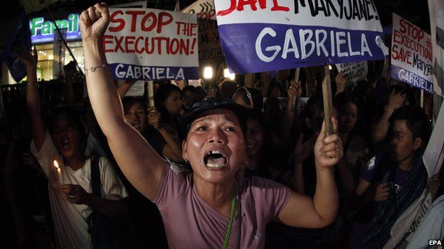 Filipino protesters stage a demonstration as they wait for the imminent execution of a Filipino mother, in front of the Indonesian embassy in Makati city on 28 April 2015
