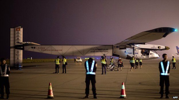 Chinese security staff members stand guard shortly before Solar Impluse 2 takes off from Nanjing international airport early on 31 May 2015