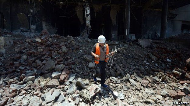 An Egyptian worker collects wires following the demolition of the headquarters of the once-dominant party of ex-president Hosni Mubarak on 31 May 2015 in Cairo