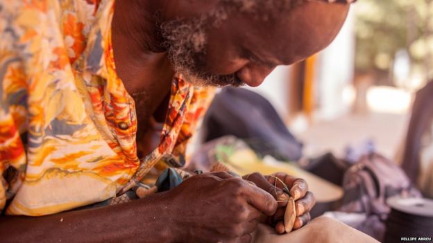 A man sewing up an amulet or gris-gris