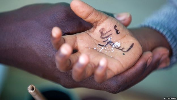 A pupil's hand with "Allah" written on it