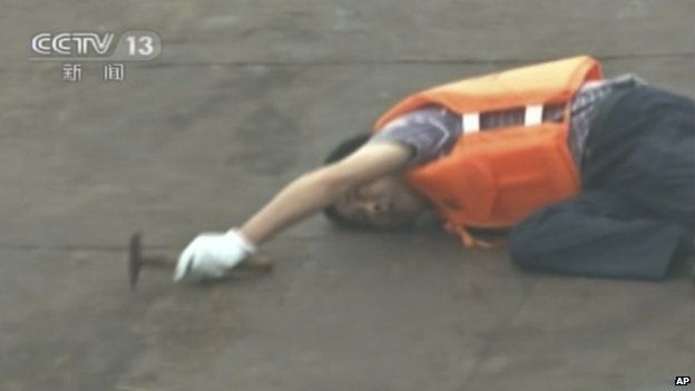 In this image taken from video released by China's CCTV, a rescue worker listens for a response as he taps on the hull of a capsized ship on the Yangtze River in central China"s Hubei province Tuesday, 2 June 2015