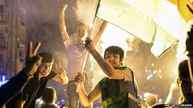 Supporters of the pro-Kurdish Peoples" Democratic Party (HDP) hold a Kurdish flag and celebrate in the streets the results of the legislative election, in Diyarbakir on June 7, 2015.