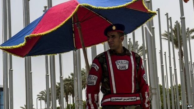 An Egyptian Republican Guard stands guard under an umbrella outside the venue of a ministerial meeting of the Common Market for Eastern and Southern Africa, East African Community and Southern African Development Community, in the Egyptian Red Sea resort of Sharm al-Sheikh, on 9 June 2015, on the eve of a summit to launch a three-way free trade area.