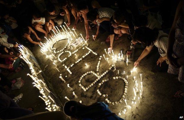 Malaysian lights up candles at a candlelight vigil for the victims of the earthquake in Kota Kinabalu, Malaysia on Monday, 8 June 2015