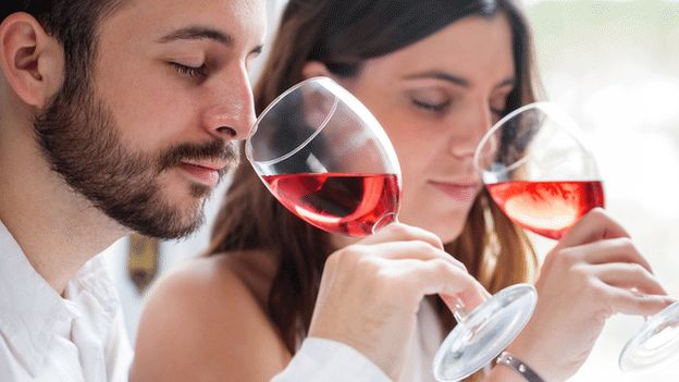 Two people tasting wine