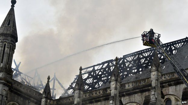 Firefighters works after a spectacular blaze that ravaged the roof of a 19th century basilica in Nantes, western France on june 15, 2015.