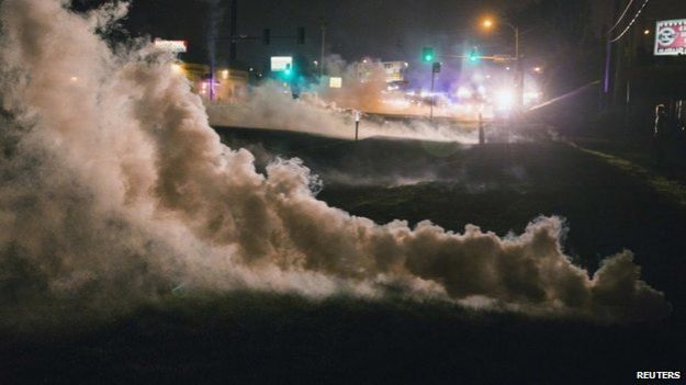 Tear gas rises from the ground after having been fired upon protesters who are continuing to react to the shooting of Michael Brown, in Ferguson, Missouri on 17 August 2014.