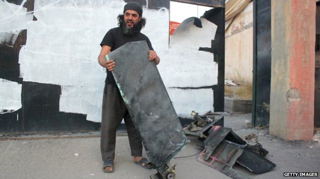 An Islamic State fighter holds parts of a US drone