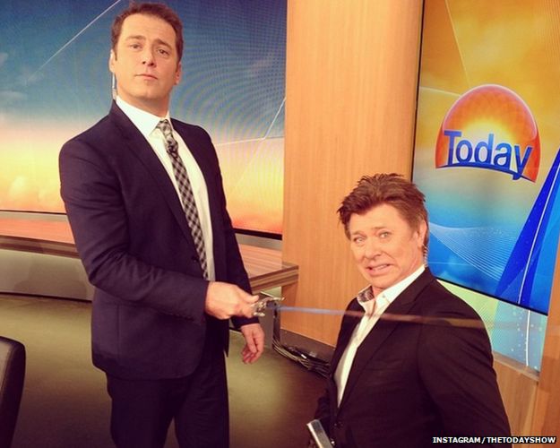 Karl Stefanovic wearing the blue suit, knighting someone with a sword