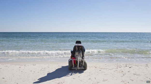 A wheelchair in front of the shoreline