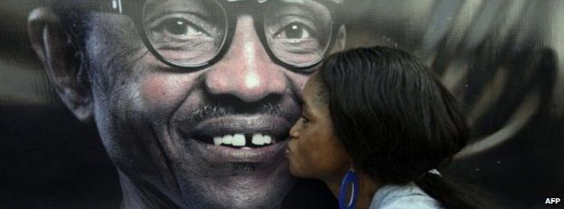 A party member kisses a poster depicting former Nigerian military ruler and presidential aspirant of the opposition All Progressives Congress (APC) Muhammadu Buhari - December 2014