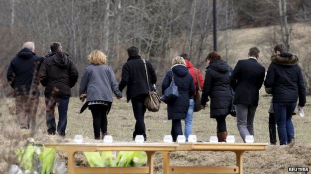 People identified by the mayor of Le Vernet as family members of the pilot of the Germanwings Airbus A320 walk near the memorial for the victims of the air disaster in the village of Le Vernet, near the crash site of the Germanwings Airbus A320 in French Alps, 28 March 2015