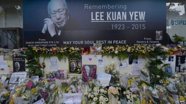 Pictures and flowers are seen in front of a memorial area for Singapore's late former prime minister Lee Kuan Yew outside the parliament building where he lies in state ahead of his funeral in Singapore, 28 March 2015