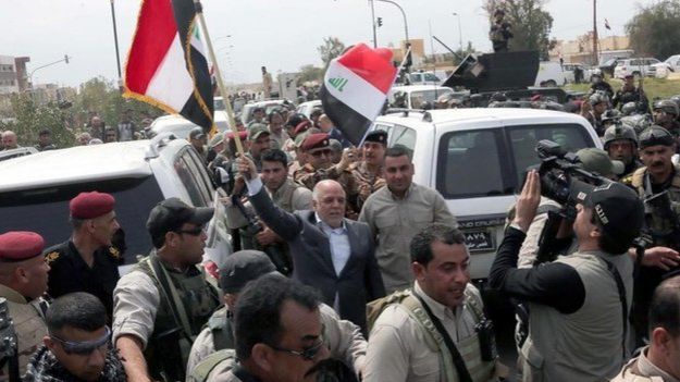 Iraqi Prime Minister Haider al-Abadi waves an Iraqi flag in Tikrit (1 April 2015)