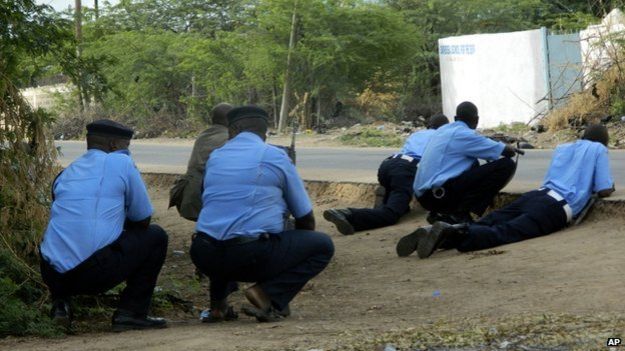 Kenyan police officers take cover outside the Garissa University College during an attack by gunmen in Garissa, Kenya, 2 Aprill 2015