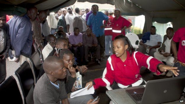Red Cross workers at Nairobi funeral home help relatives check list of survivors - 4 April