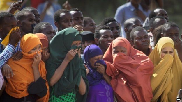 People in Garissa watch as the bodies of the dead gunmen are driven past - 4 April