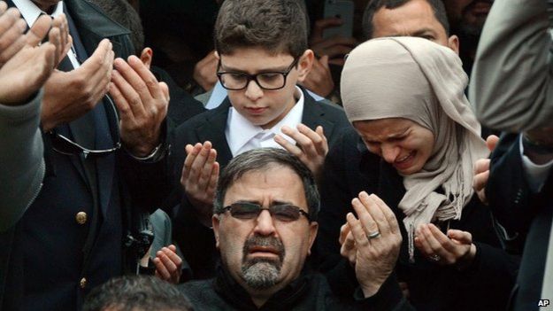 Namee Barakat, center, watches during funeral services for his son, Deah Shaddy Barakat, 12 February 2015