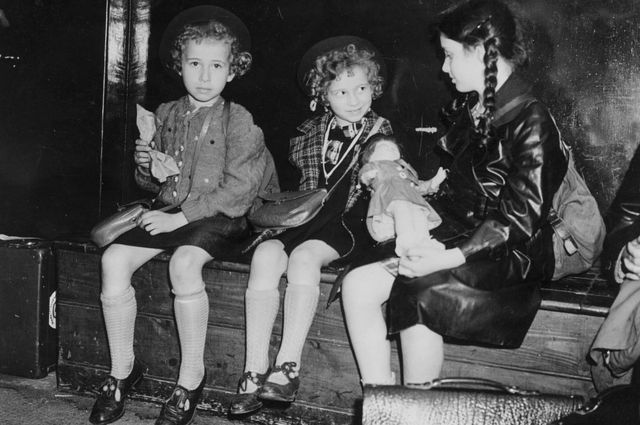 Black and white picture of three girls sitting on a bench