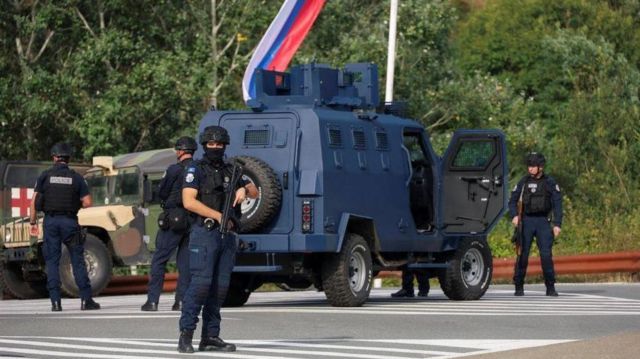 شرطة كوسوفو في مكان الحادث مع قوات من الولايات المتحدة والاتحاد الأوروبي في الخلفية