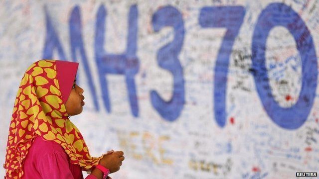 A girl looks at a board with messages of support and hope for passengers of the missing Malaysia Airlines MH370 at the Kuala Lumpur International Airport