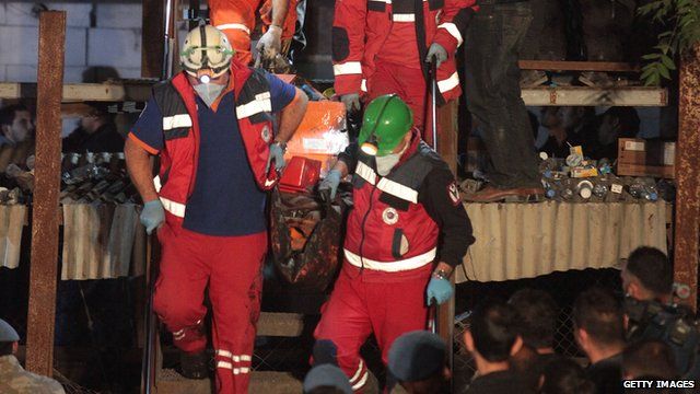 A miner is carried to an ambulance by rescuers
