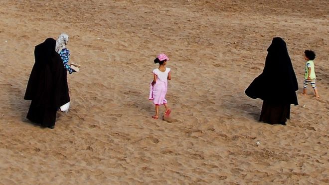 Two women wearing the niqab walk on the beach in Casablanca