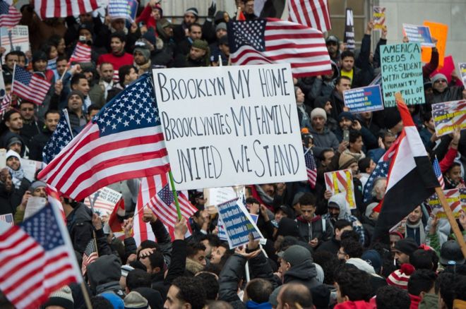 People rally with flags at Brooklyn Borough Hall as Yemeni bodega and grocery-stores shut down to protest against Donald Trump's Executive Order banning immigrants