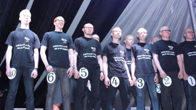 Wanaume walioshiriki katika mashindano hayo wasimama tisti jukwaani.